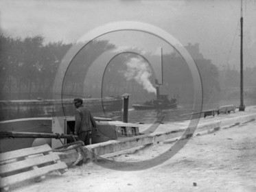 BA 1070 marinier sur sa péniche , sur la rivière remorqueur empanaché de fumée remorque un grand chaland métallique lège.jpg